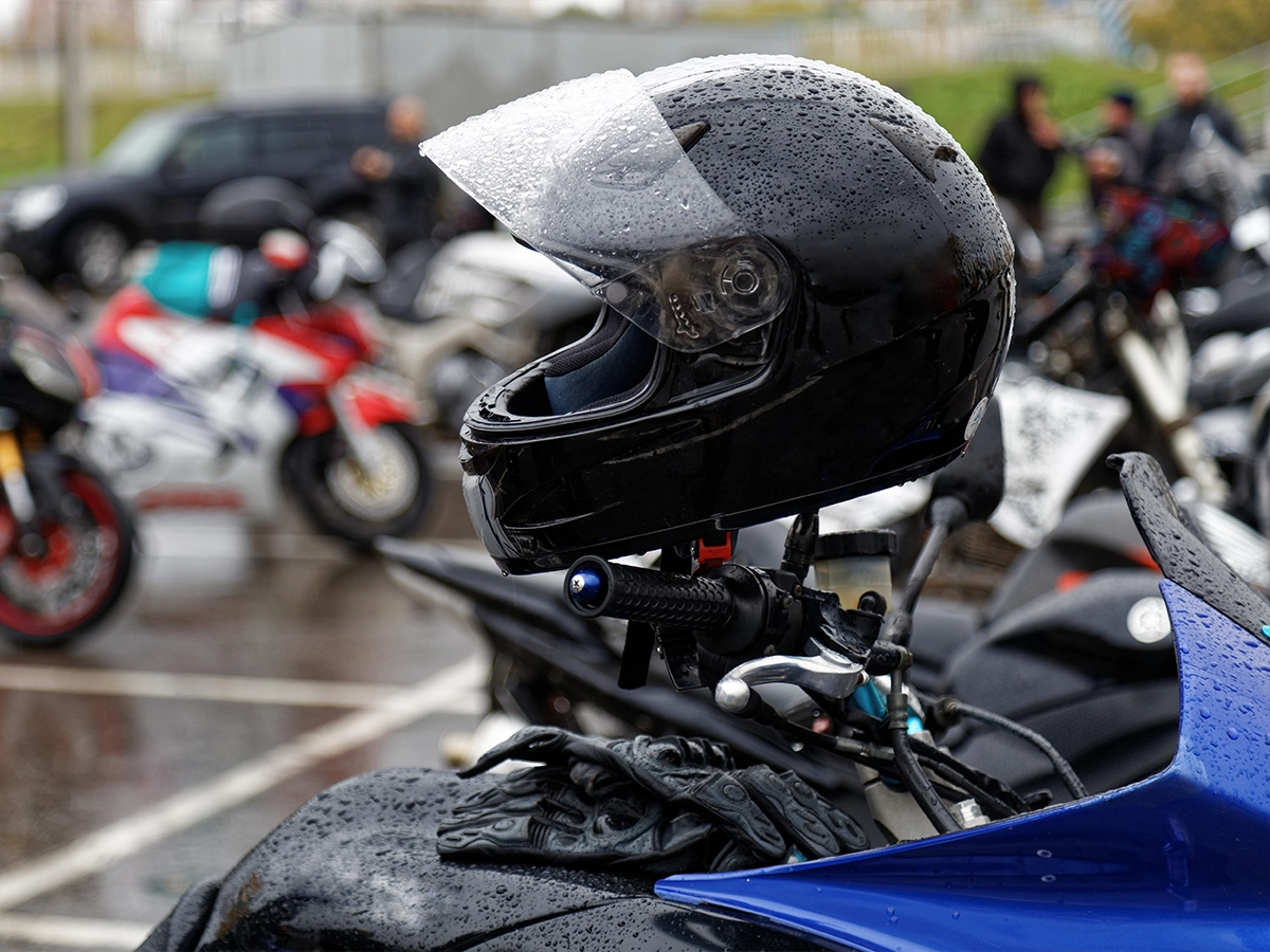 Motorrijden in de regen: helm op een motorstuur